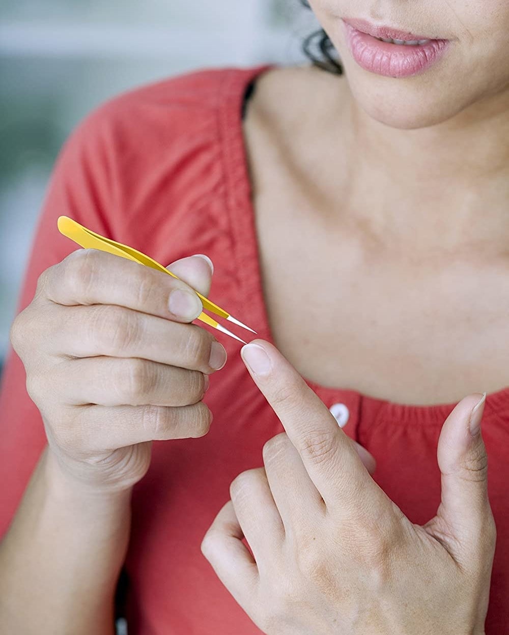 A person removes a splinter from their fingertip