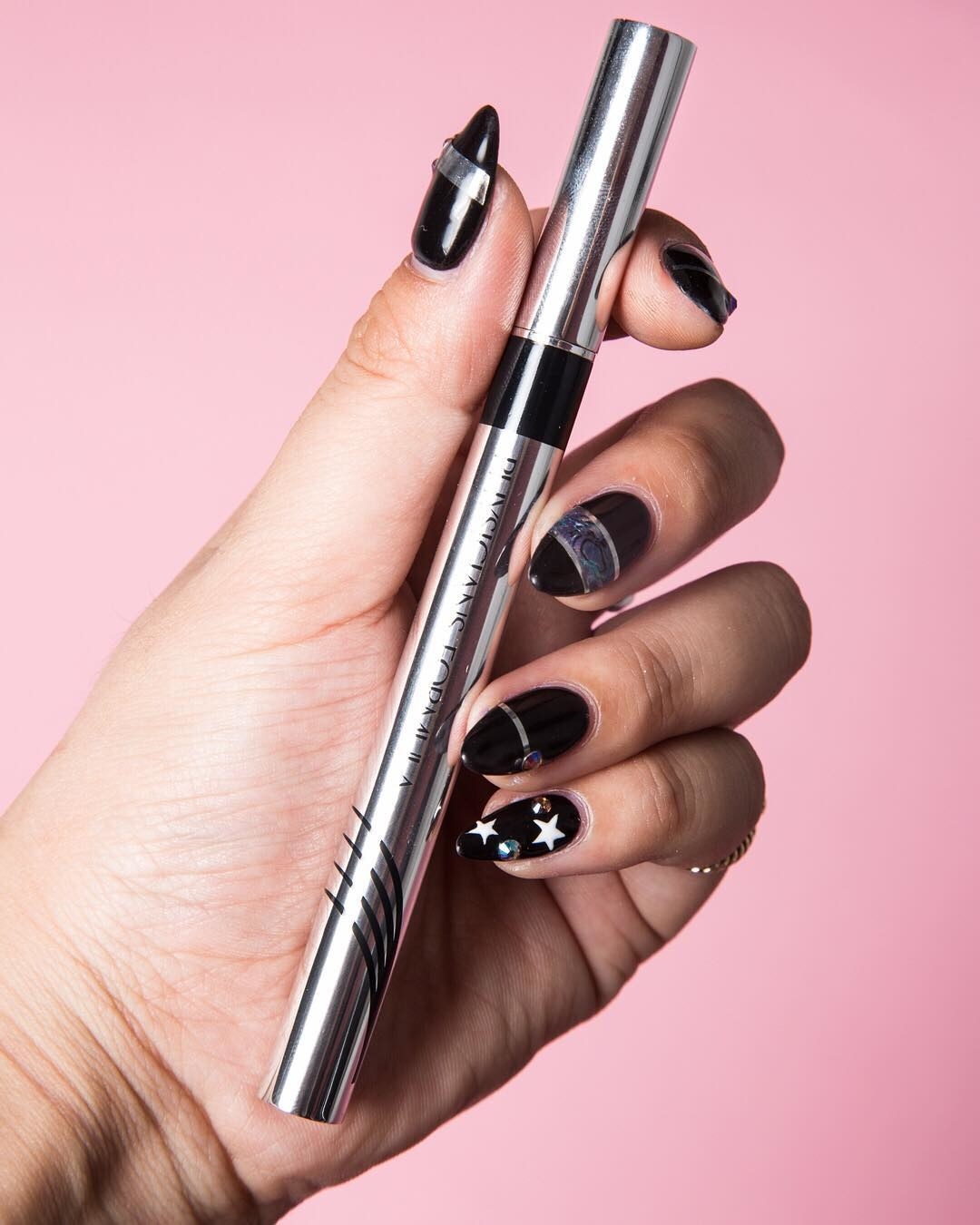 A person holds the eyeliner in their hand
