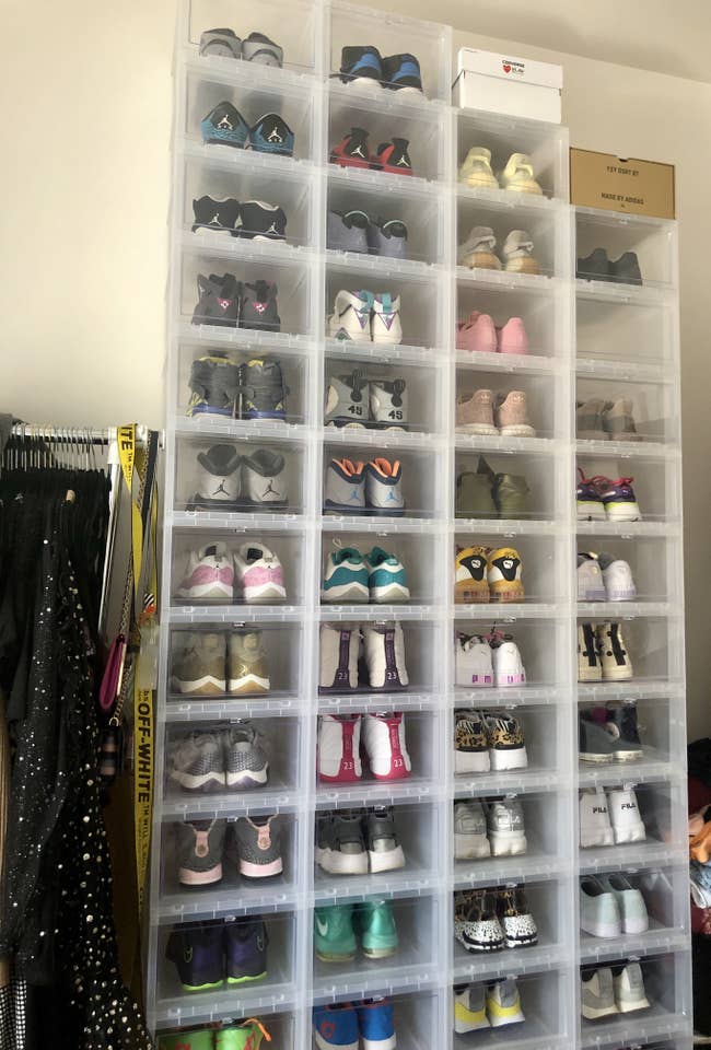 BuzzFeed editor's clear shoe boxes stacked four across and 13 high filled with sneakers in her bedroom