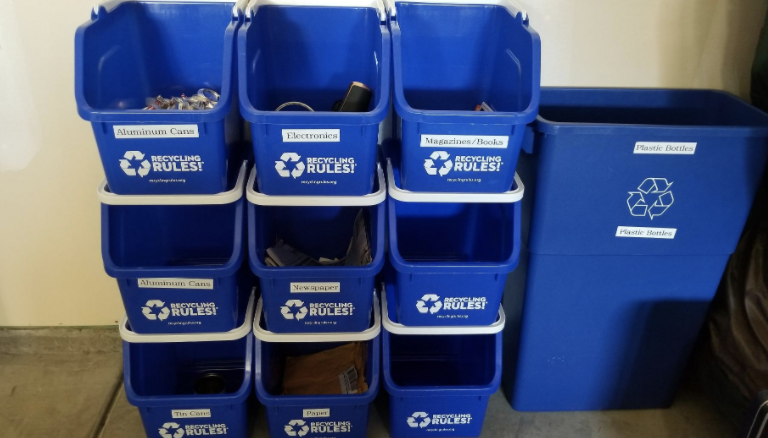 nine of the blue recycling bins stacked up in a reviewer&#x27;s garage