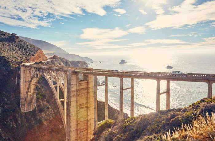 Bixby Creek Bridge at sunset with rocky cliffs and a view out across the ocean