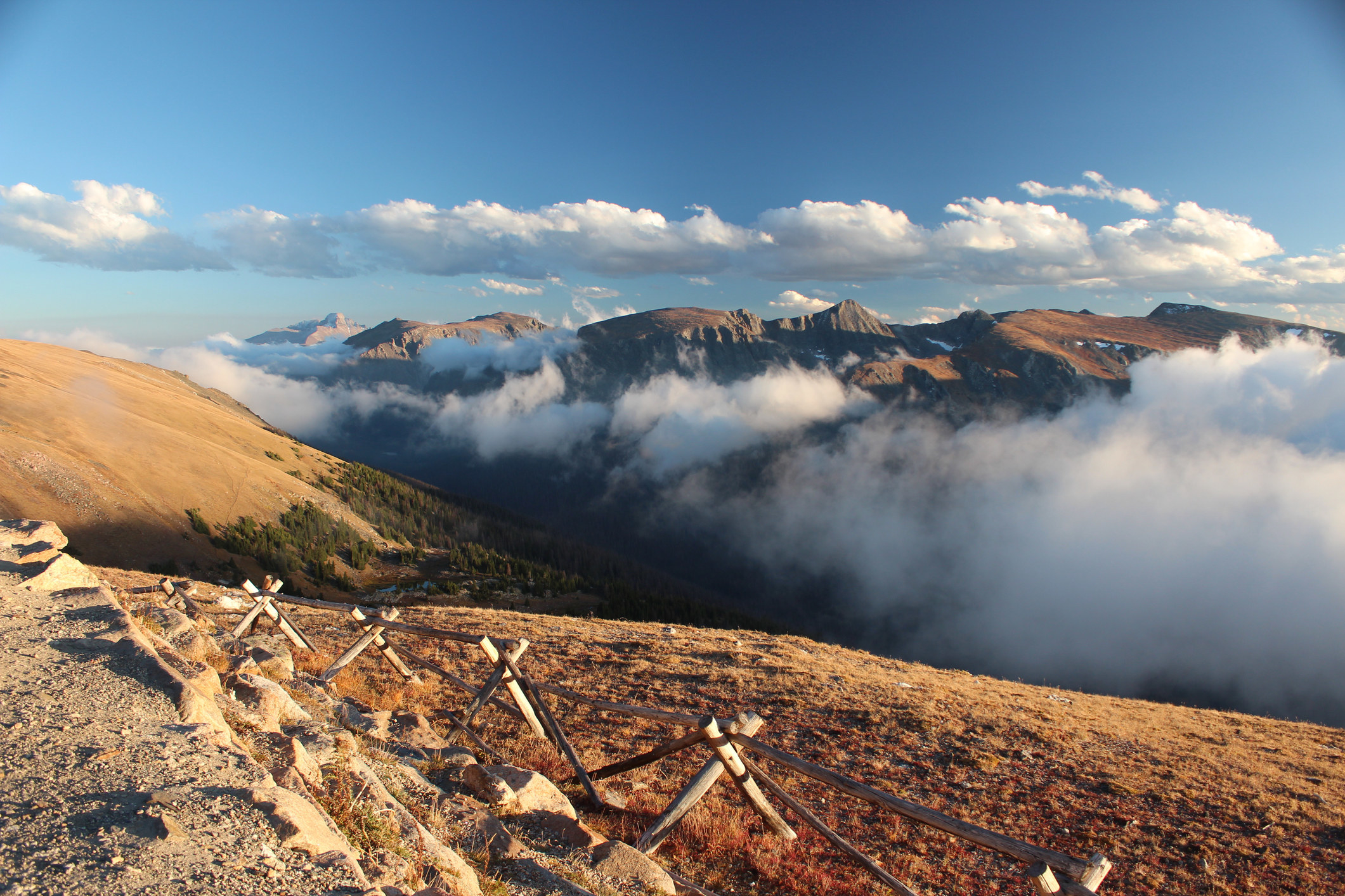 mountains poke above the clouds along Trail Ridge Road in Rocky Mountain National Park during the fall

