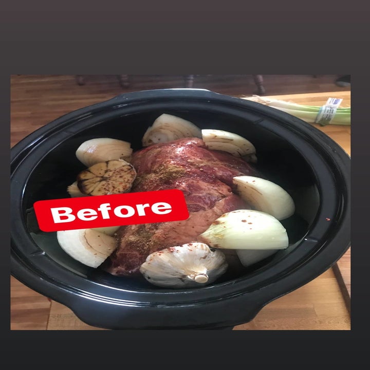 The crock pot with onions, garlic, and pork in it
