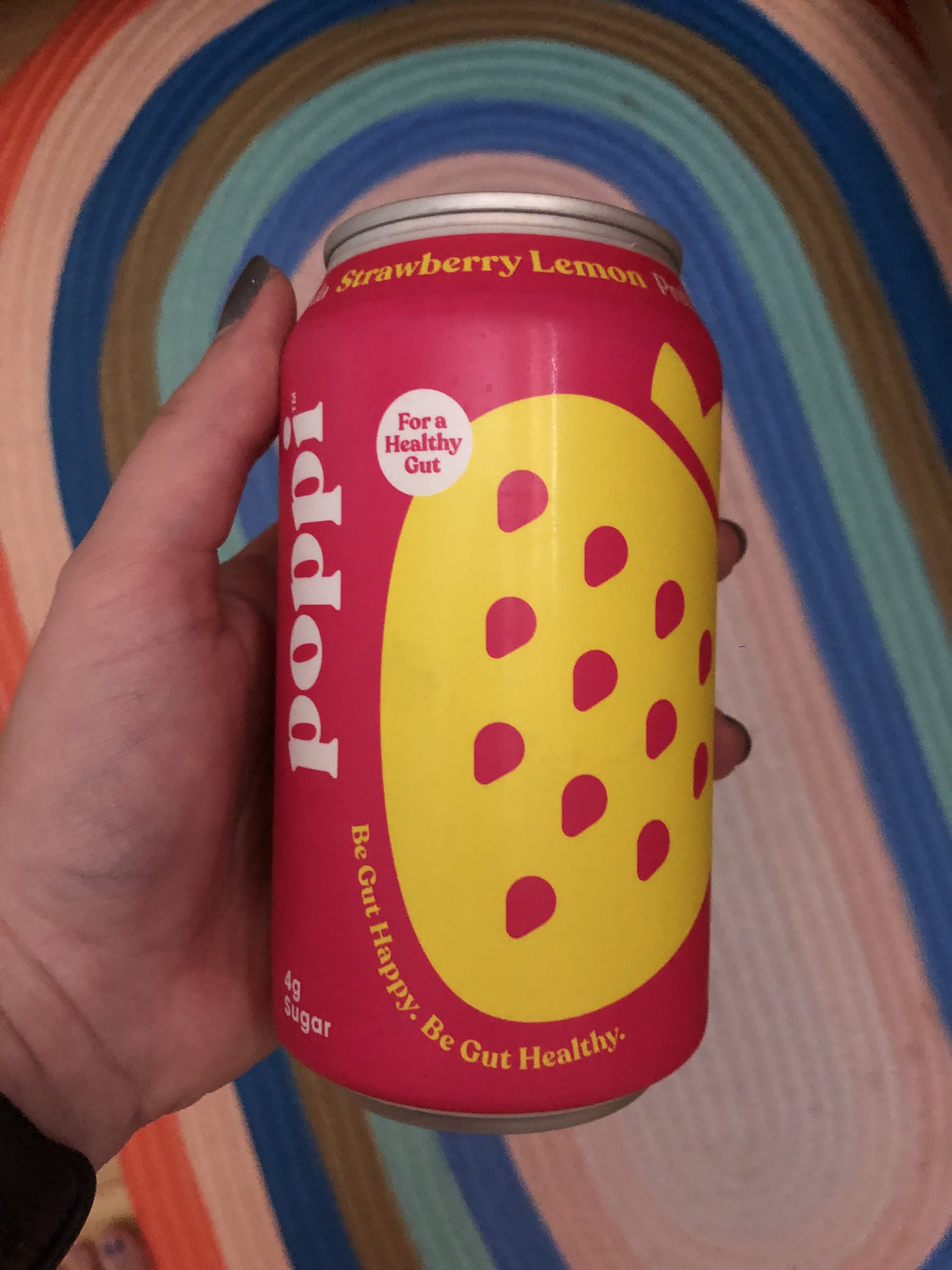 Hand holding the can of strawberry lemonade soda