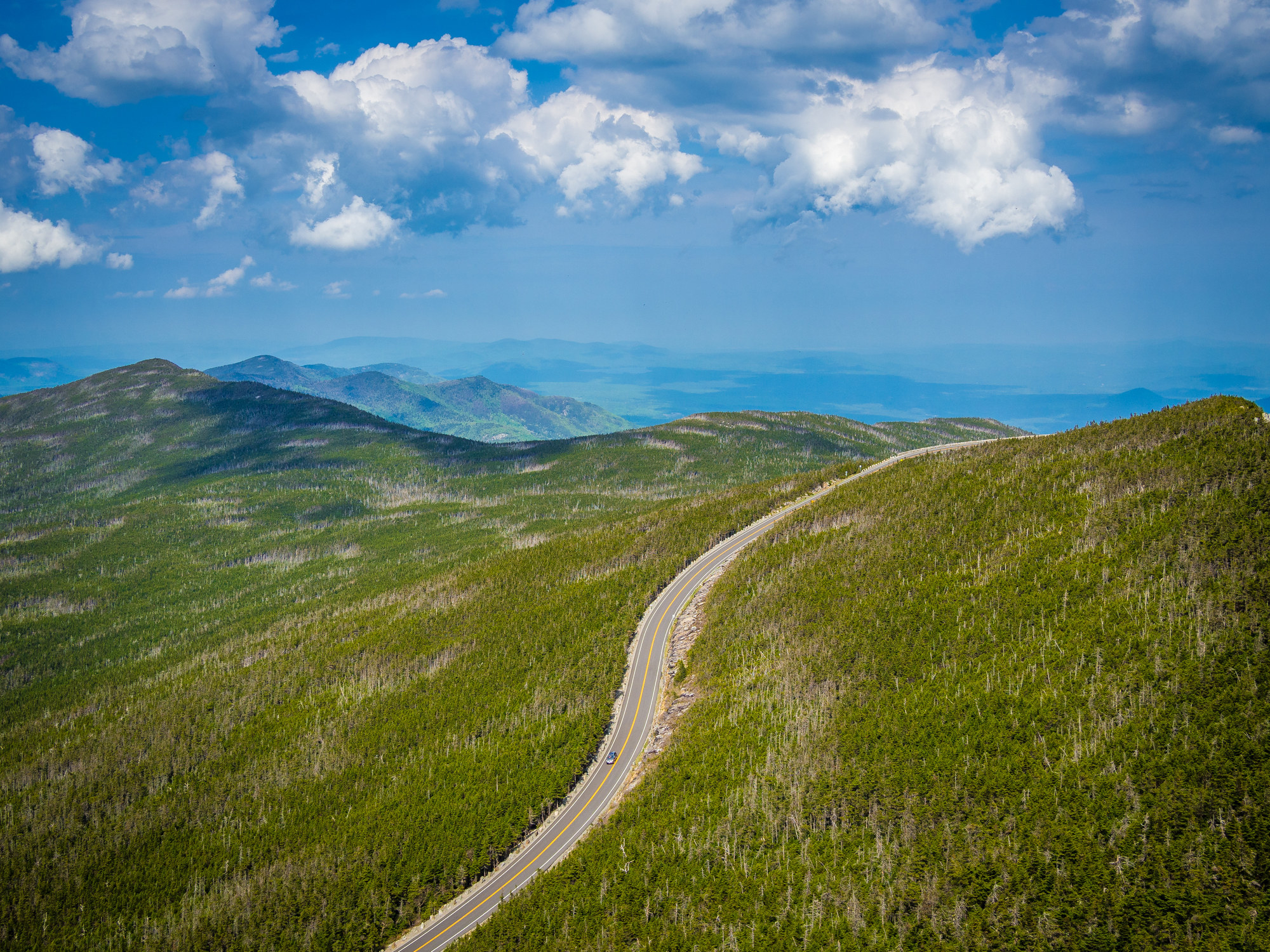 aerial view of road winding through Whiteface mountain, surrounded by greenery in Adirondack, NY, USA
