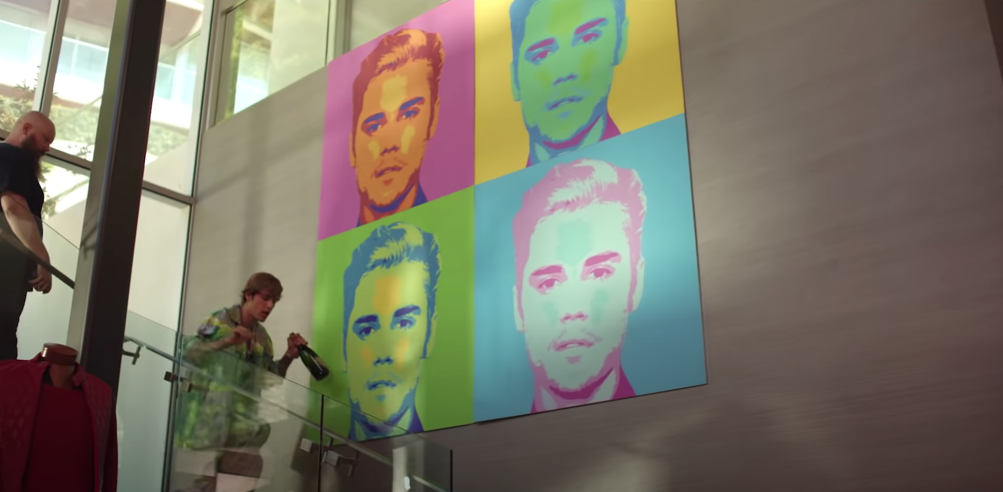 Justin walks by a colorful Andy Warhol-style pop art portraits of himself