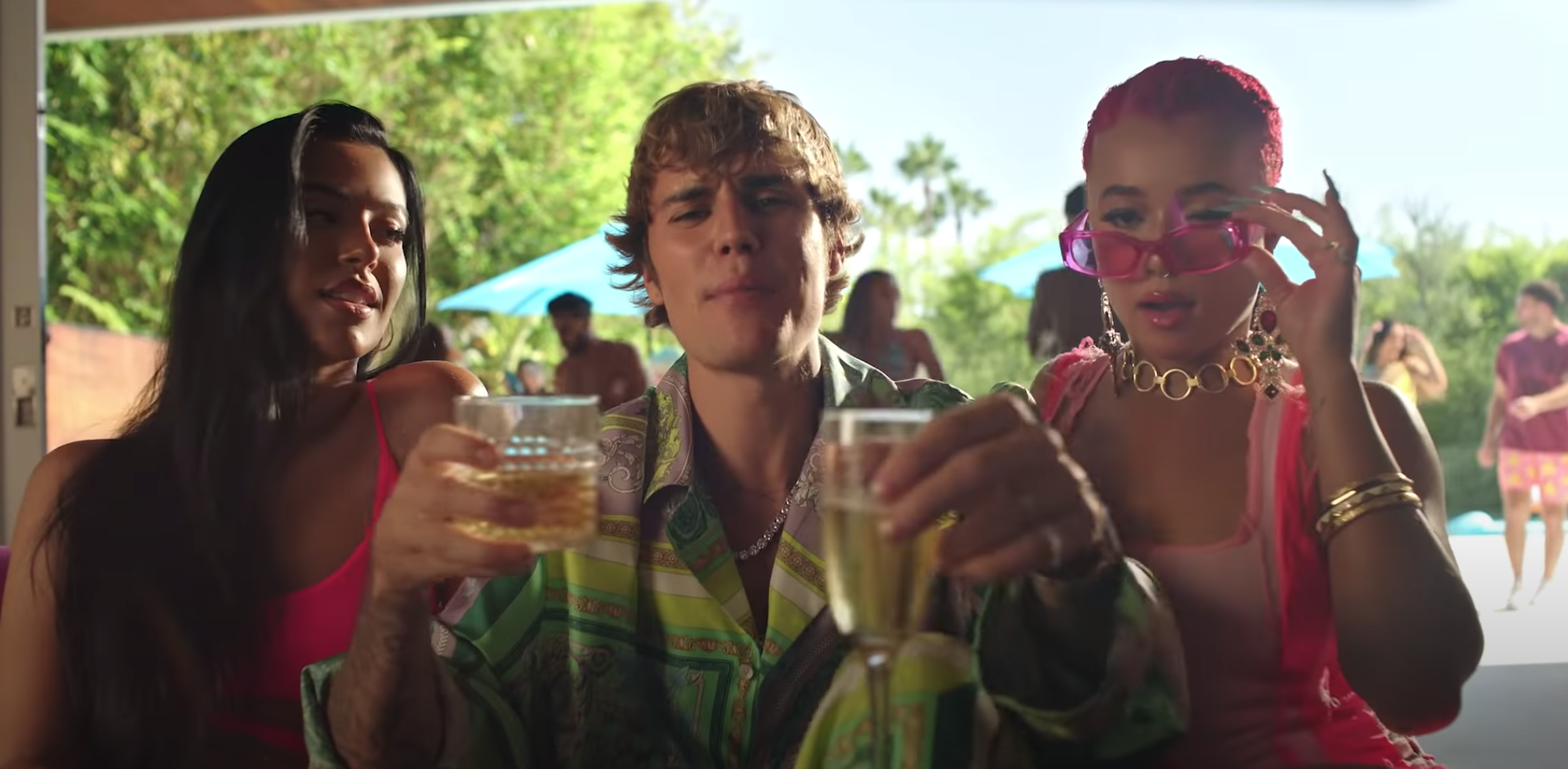 Justin sits among guests with drinks in his hands