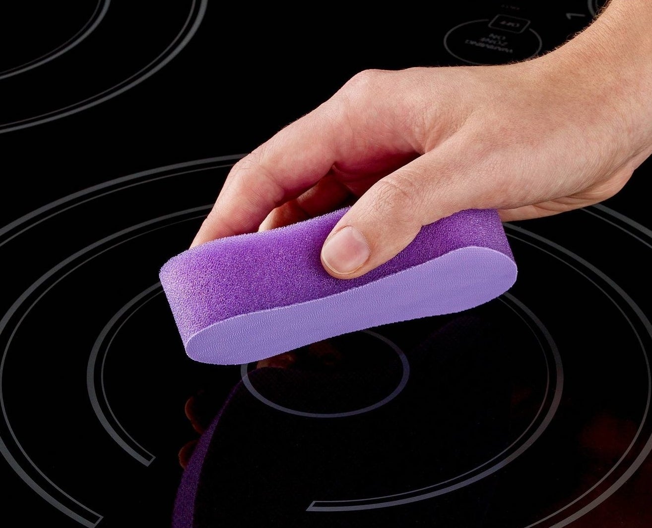Model using a pad to wipe off glass top stove