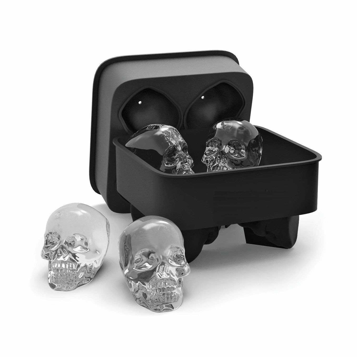 Four skull-shaped ice cubes inside and outside their black silicone container