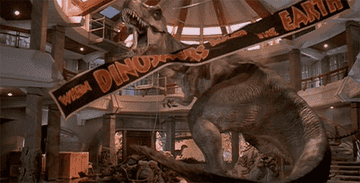 A banner reading &quot;When dinosaurs ruled the Earth&quot; floats to the ground past a vicious T-Rex