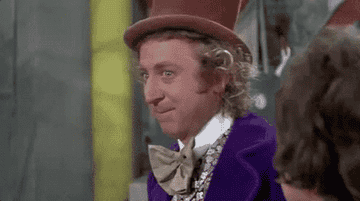 Willy Wonka leaning on his hand and looking extremely interested in the conversation.