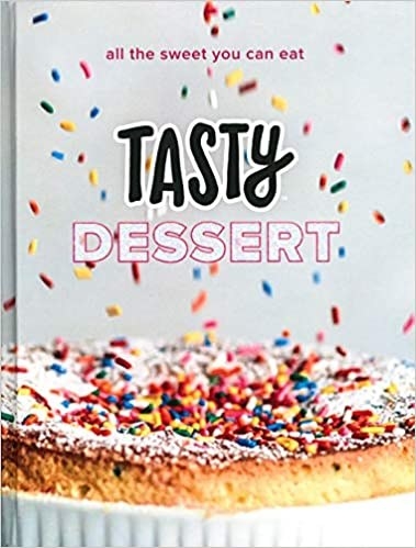 A dessert recipe book with  a picture of a cake and colourful sprinkles falling on it