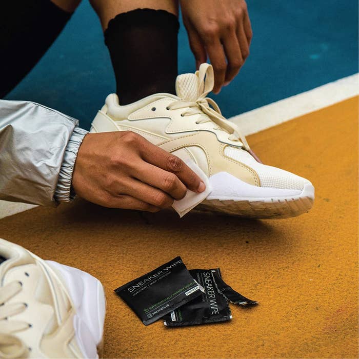 A person cleaning their shoes with a sneaker wipe