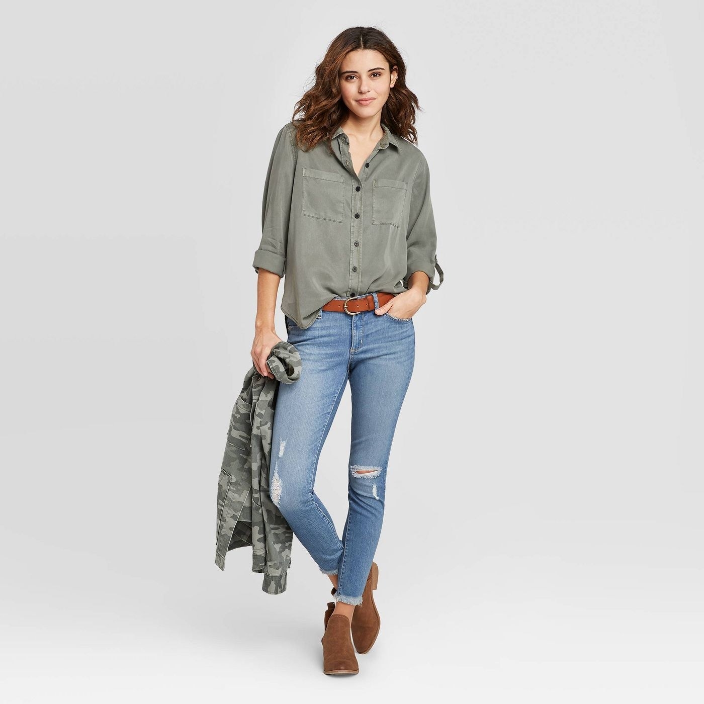 Model in flowy green long sleeve button-down shirt