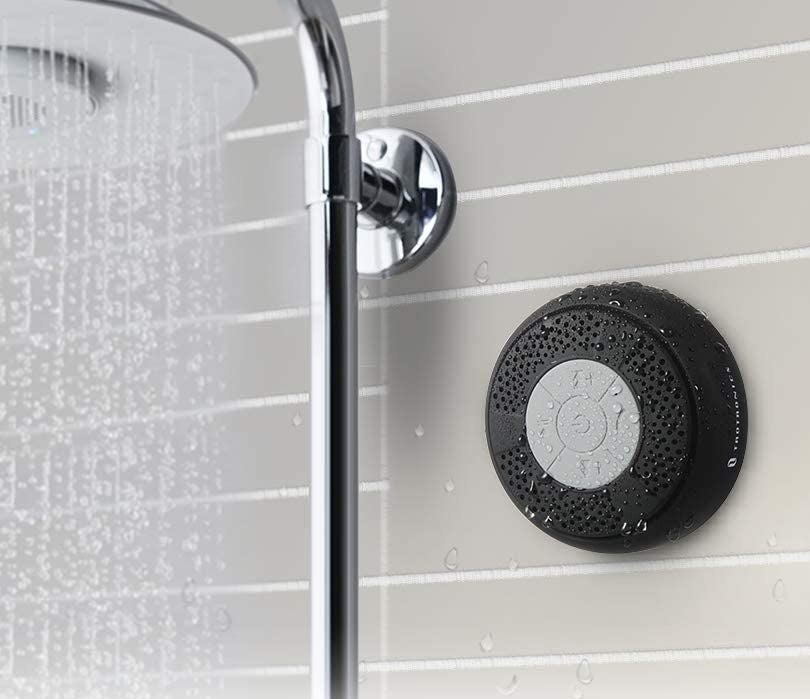 The speaker suctioned to a wall next to a shower head