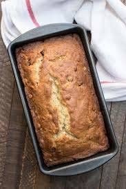 A loaf of bread in the baking tray on a wooden table