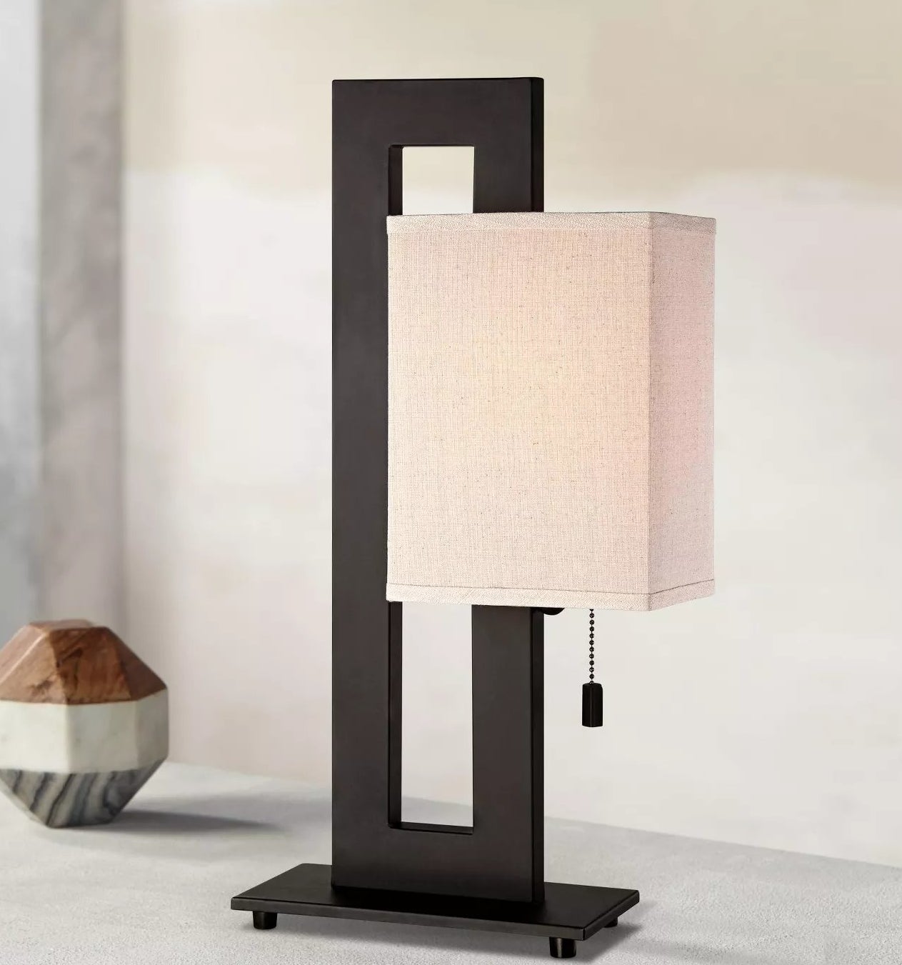 The black, asymmetrical table lamp with a beige shade