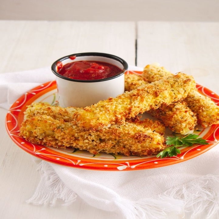 A plate of homemade crispy mozzarella sticks with marinara dipping sauce.
