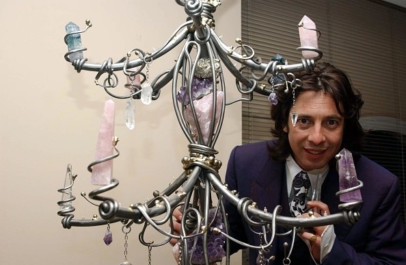 man posing with ornament with crystals 