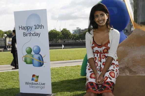 woman sat on rock next to sign smiling