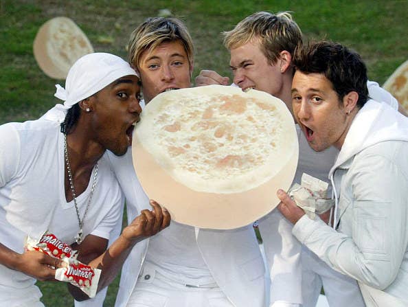 boyband blue hold giant white malteaser and taking a bite out of it