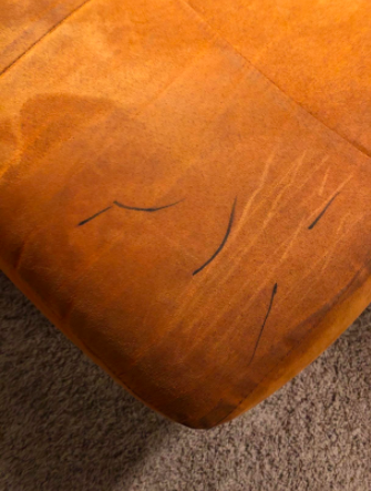 reviewer pic of brown suede couch with black sharpie marks on it 