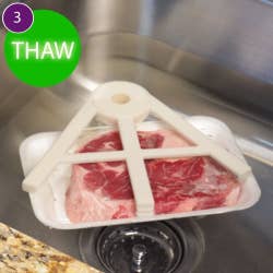 The claw holding a packaged steak under water with the text 3) Thaw