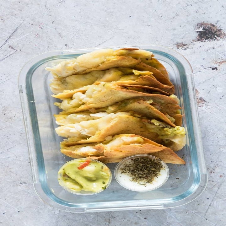 A top-down shot of the chicken and cheese quesadilla, sliced into little triangles with two dipping sauce on the side.