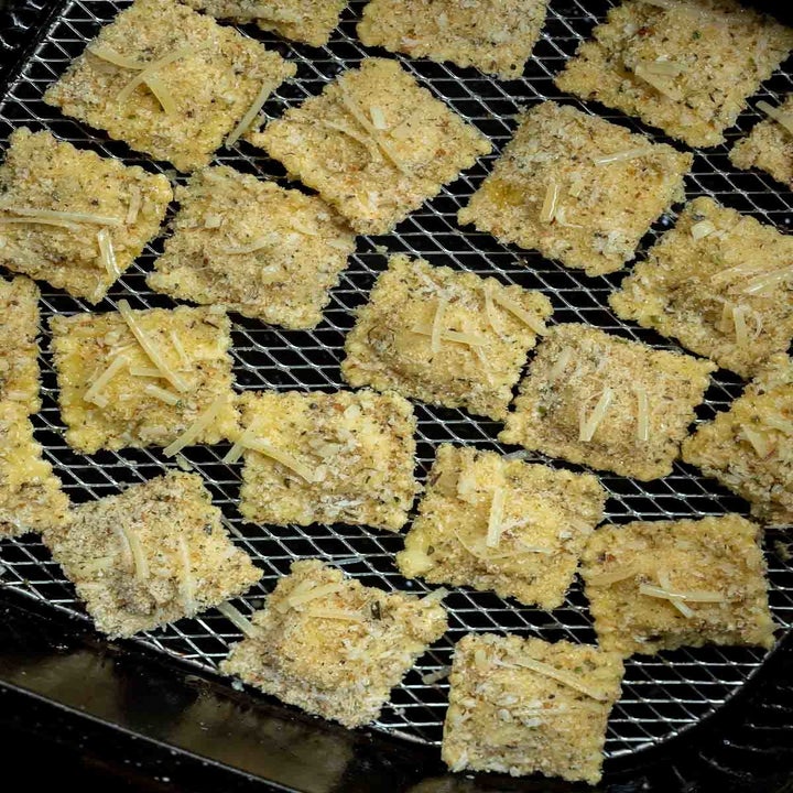 Ravioli topped with bread crumbs and seasonings in the air fryer.