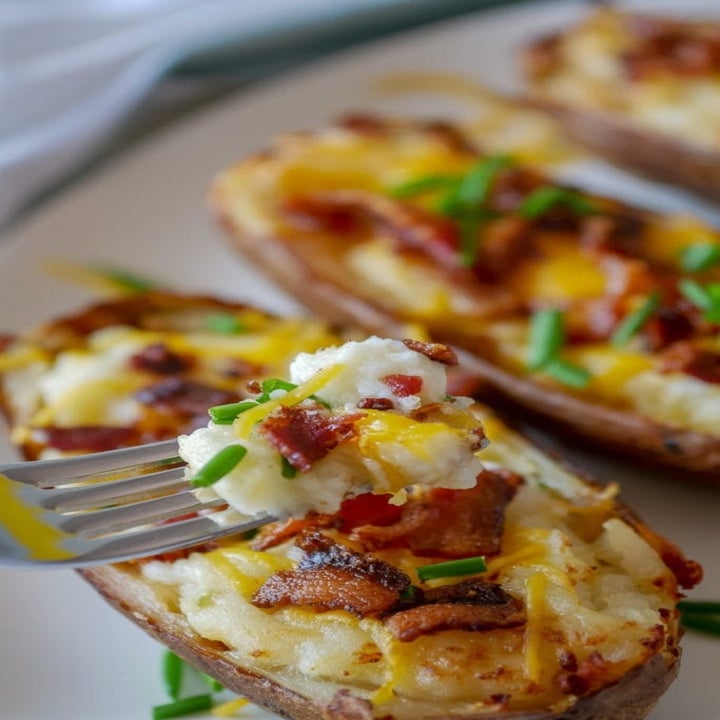 A fork taking a scoop from a twice baked potato.