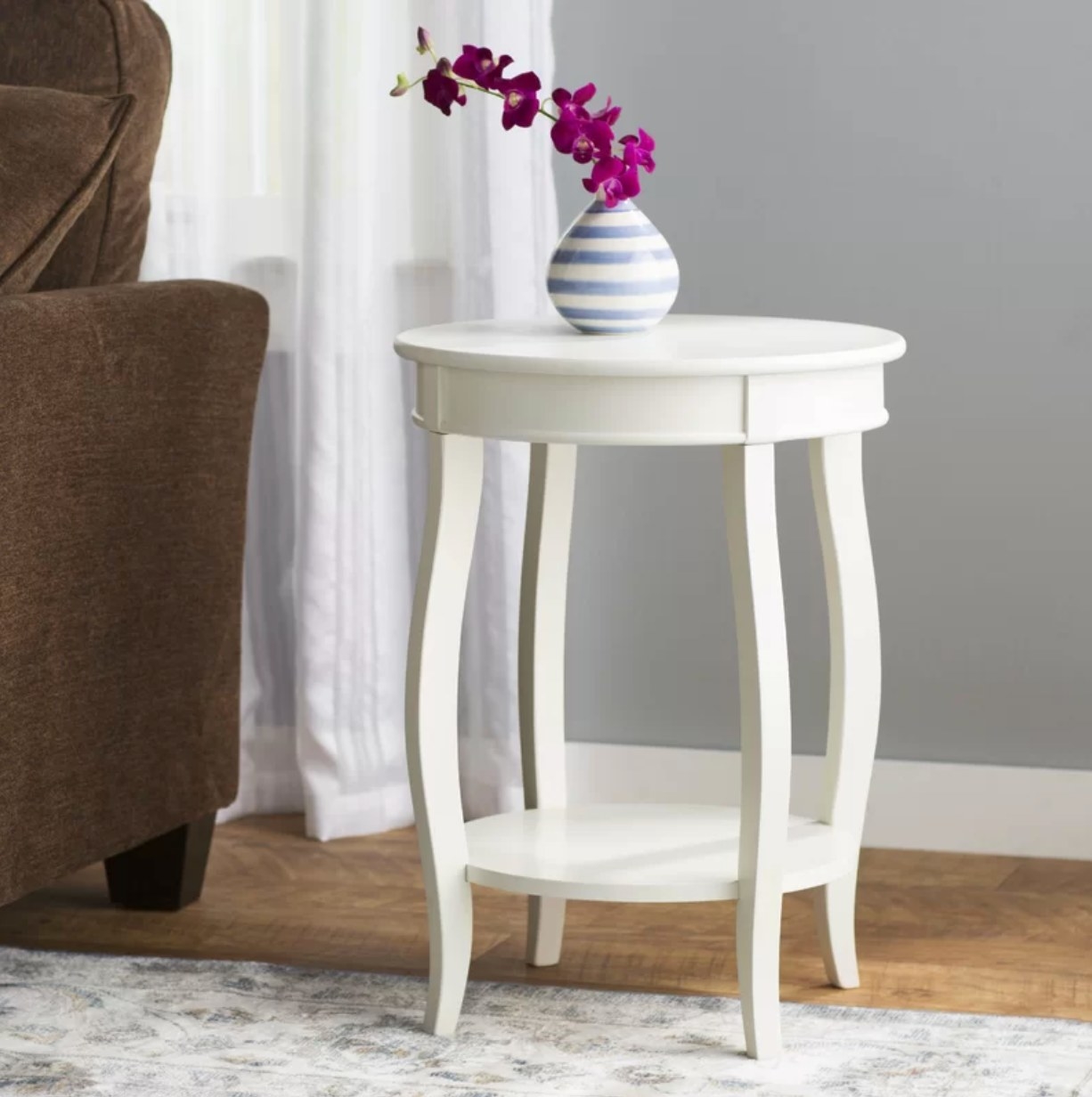 The side table in white being used as a vase holder
