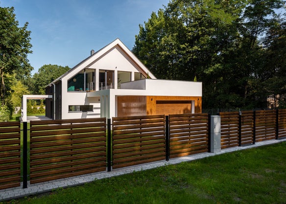 A home with very strong geometric features and a big fence.