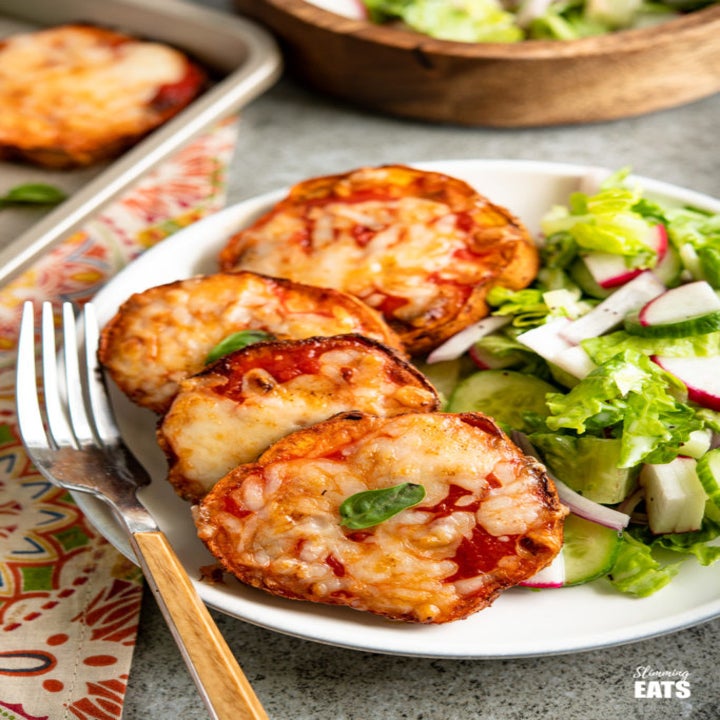 Four sweet potato pizza slices on a plate with a side salad.