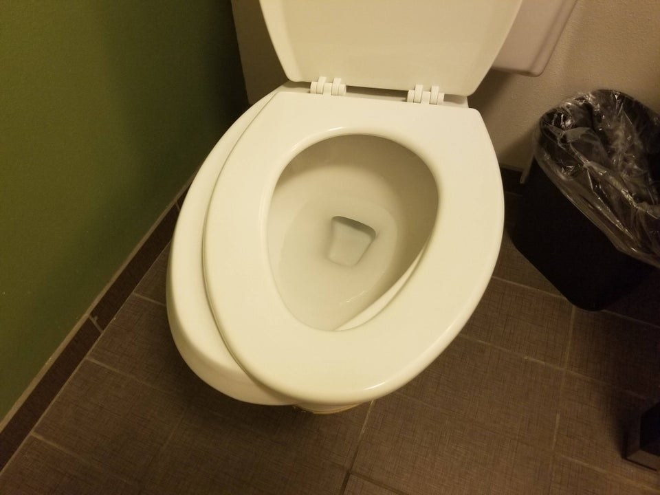 A toilet seat that&#x27;s crooked because it isn&#x27;t screwed on tightly enough