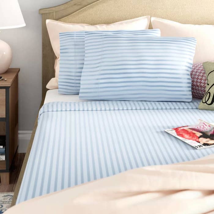 The sheets in blue stripe on a bed