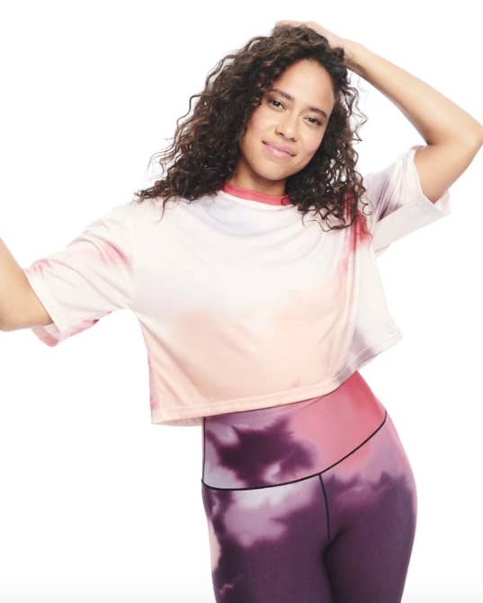 Model wears Day/Won pink, red, and purple tie-dye crop top with purple tie-dye leggings