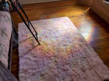 a ray of light creating a rainbow on a rug and hardwood floor thanks to the iridescent window film