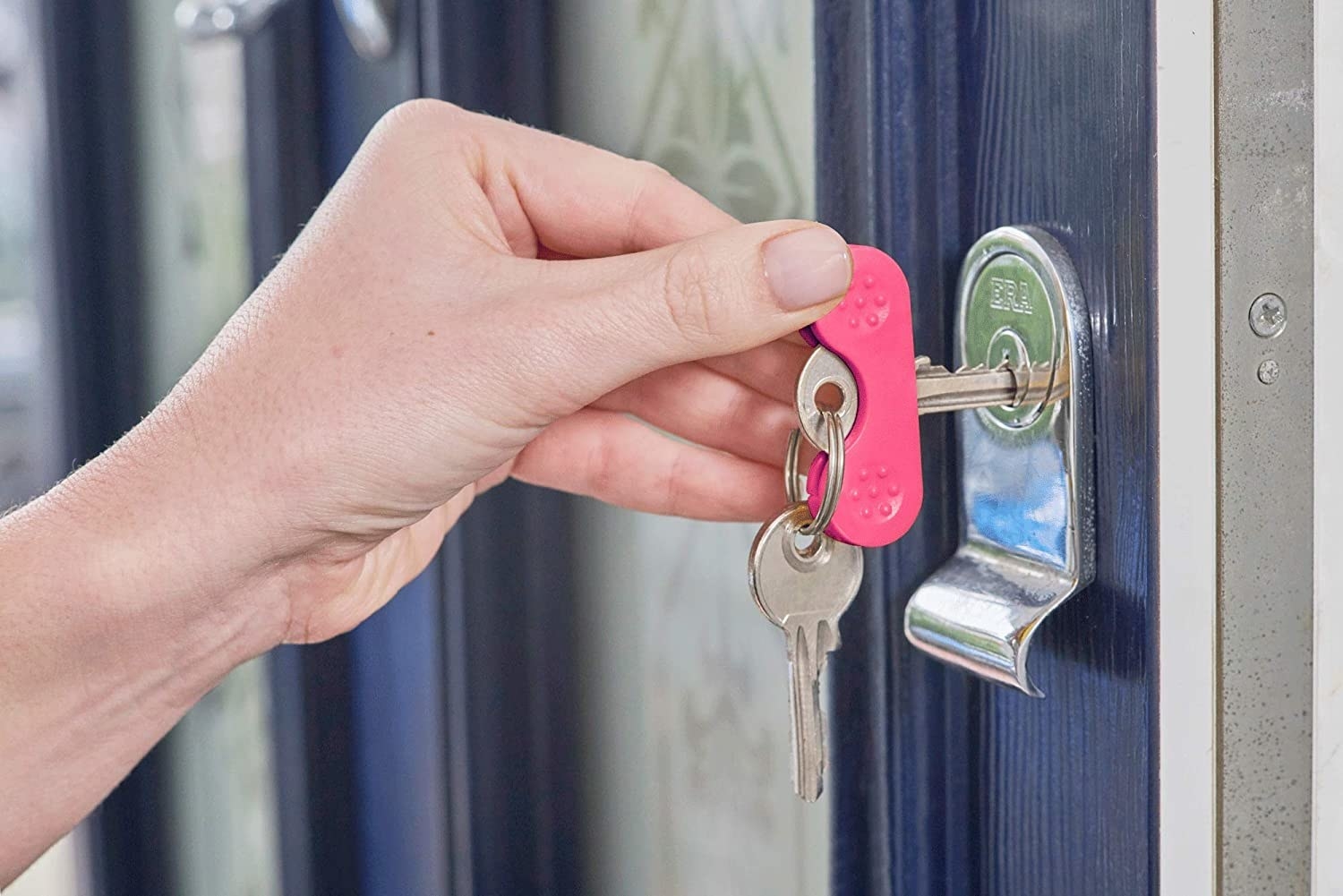 Person with attached key turner unlocking door