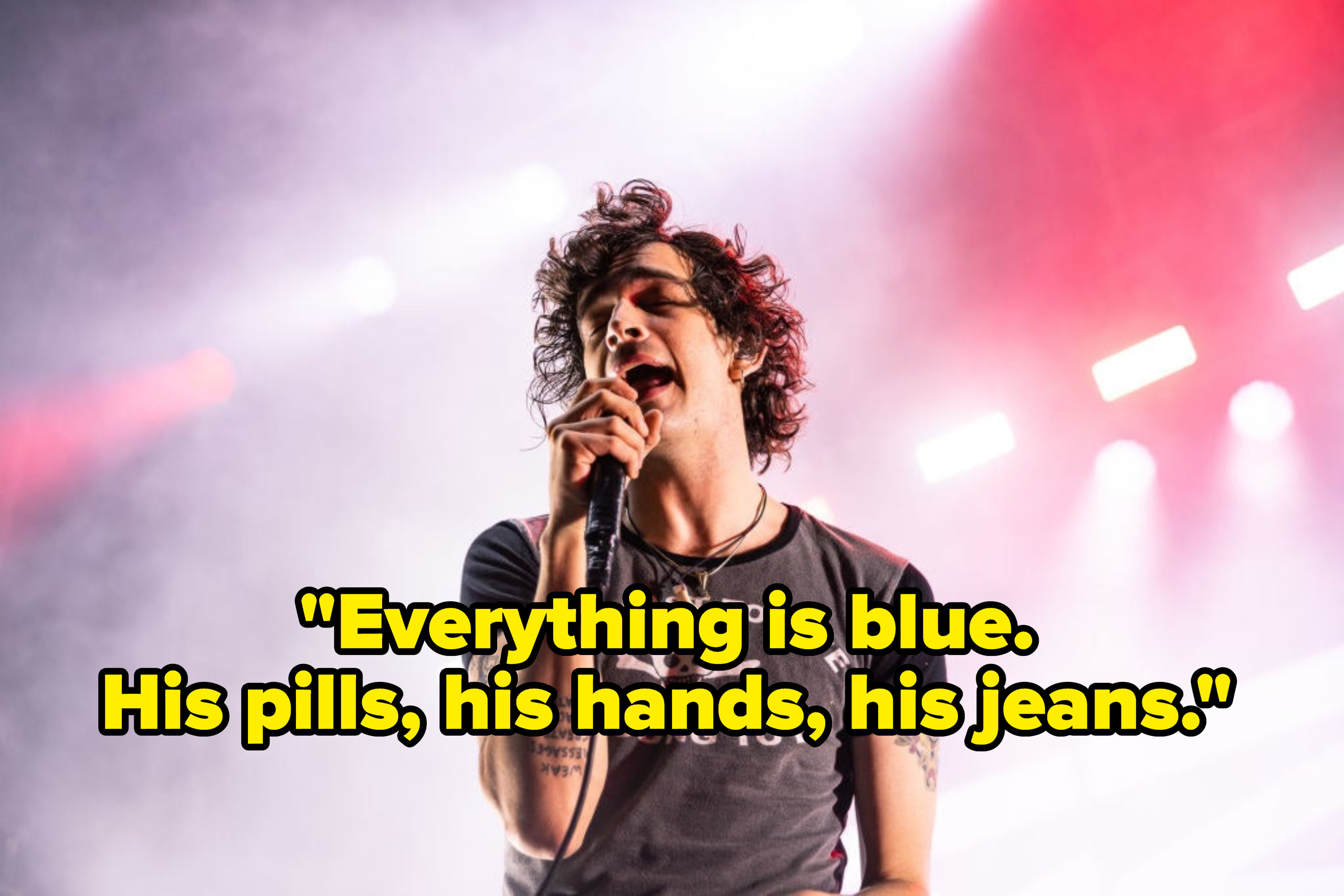 Matty Healy singing on stage, captioned with the song lyric, &quot;Everything is blue. His pills, his hands, his jeans.&quot;