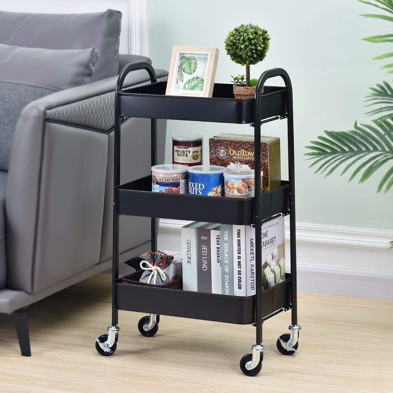 A utility cart with books, snacks, and decor accessories on it