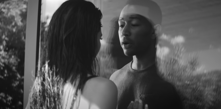John Legend and Chrissy Teigen looking at each other through a window in the &quot;All of Me&quot; music video