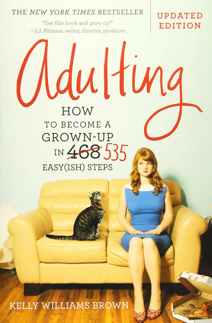 The cover of the book which shows a young woman and her cat sitting on a couch
