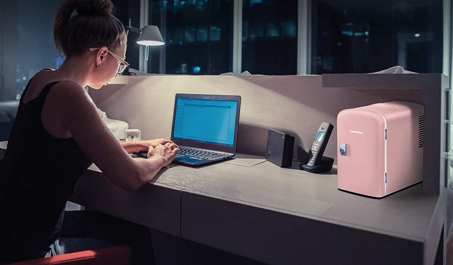 A mini fridge sits on a desk
