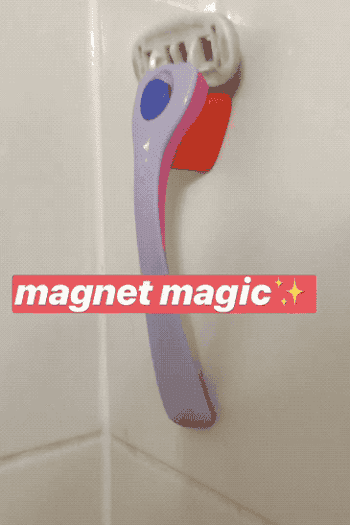 A GIF of a hand pulling the pink and purple razor on and off the magnetic holder mounted to a wall with the text 
