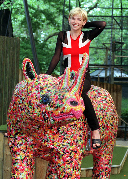 woman sat on rhino statue made of jelly beans