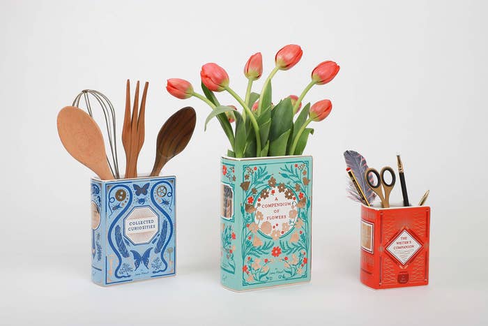 Three different designs of the book vase, containing flowers, kitchen utensils, and stationery.