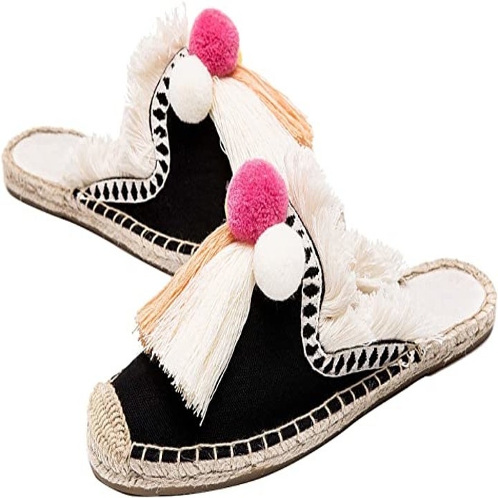 the shoes in black with pink and white tassels on the front