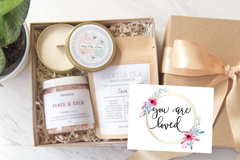 A mindfulness gift box containing a note, candle, scrub, and tea.