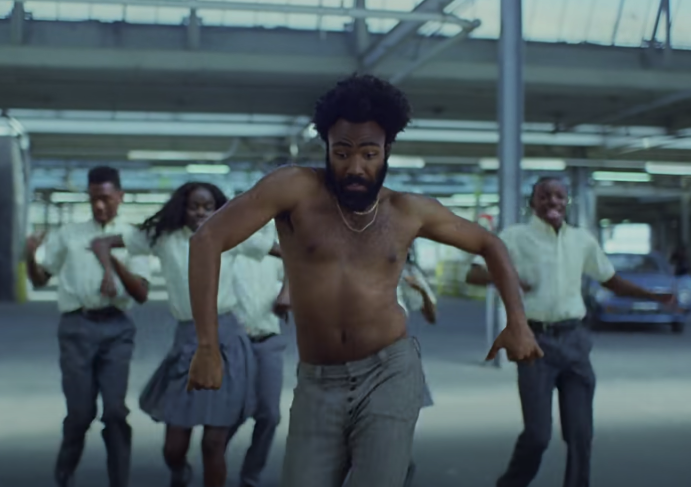 Childish Gambino dancing in an abandoned lot with kids behind him