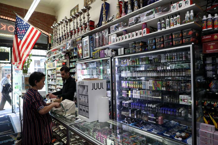 A customer talks to a cashier at a vape shop in San Francisco, surrounded by vapes and vaping liquid supplies